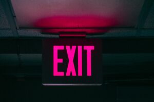 Illuminated exit sign in a dark hallway.